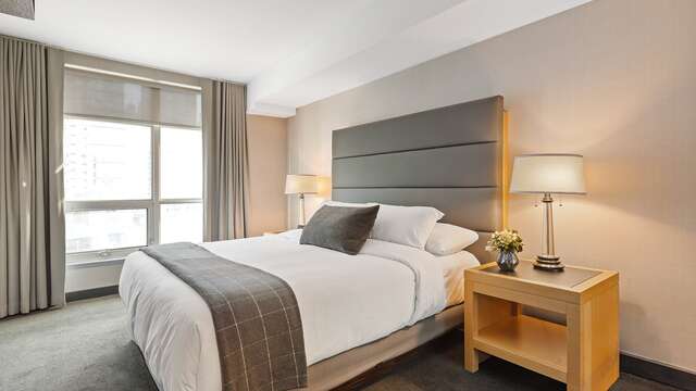 Comfortabele hotelkamer met een groot tweepersoonsbed, perfect voor een romantische geschenkdoos met diner.