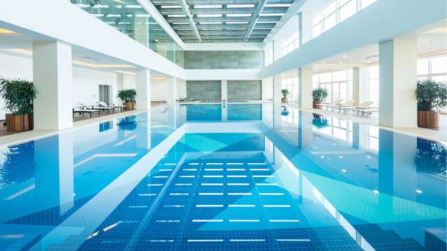 Grande piscine intérieure d'un circuit de spa, un élément clé pour un week-end spa de luxe.